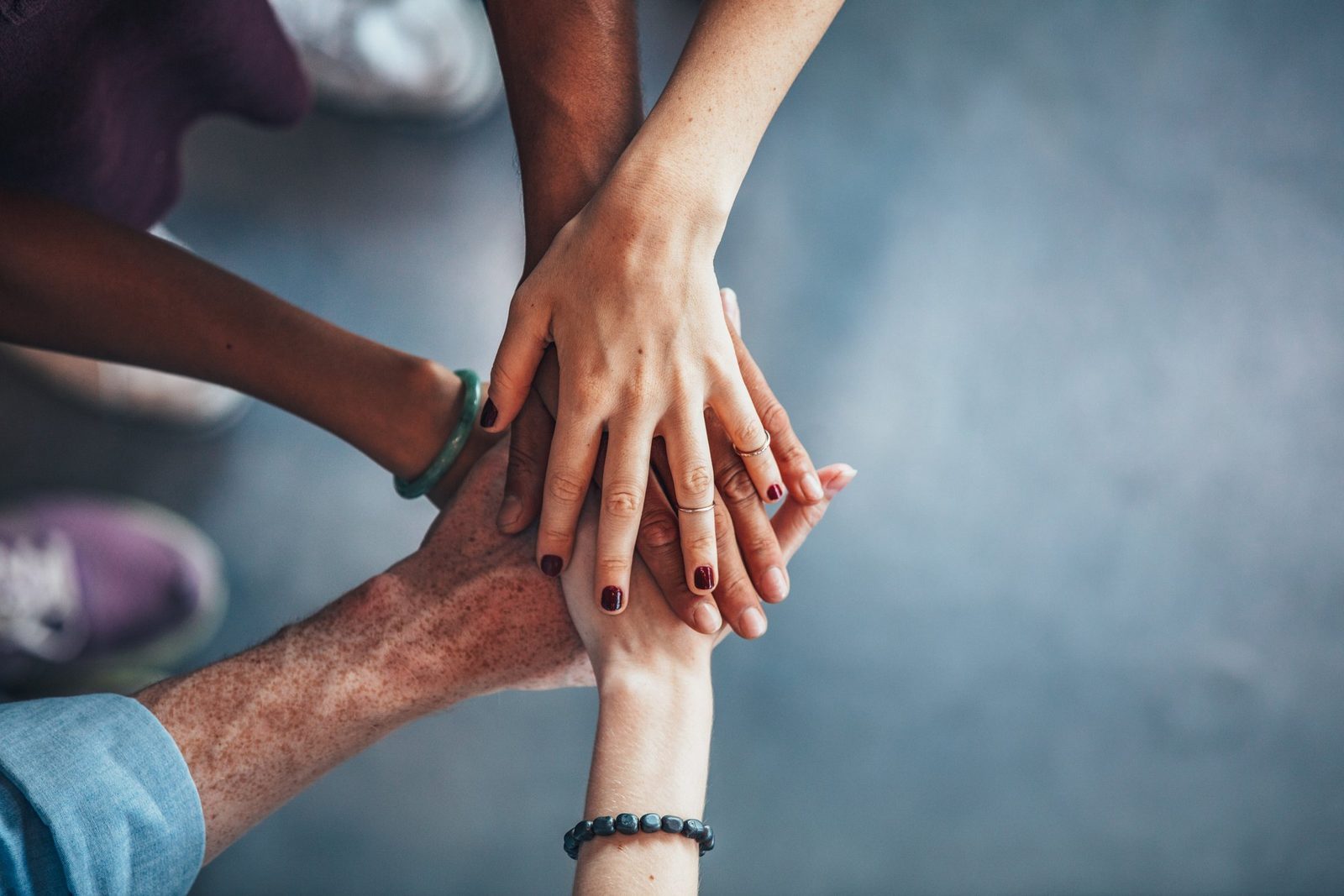 Several hands resting on top of one another