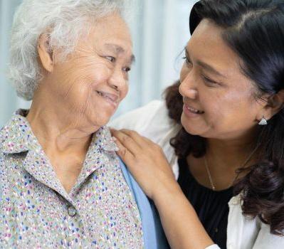 A caregiver sharing a smile with an older woman